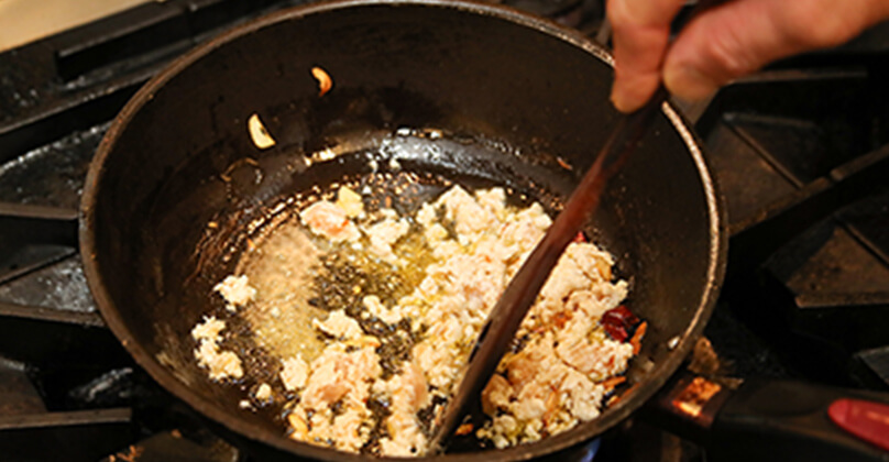 フライパンにオリーブオイル（にんにくと鷹の爪で香りをつける）と鷄肉を入れて炒める。